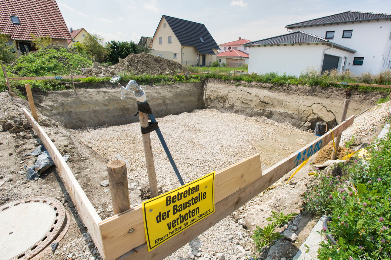 Baustelle für das Fundament eines Wohnhauses mit Schild in deutscher Sprache: Betreten der Baustelle verboten – Eltern haften für ihre Kinder