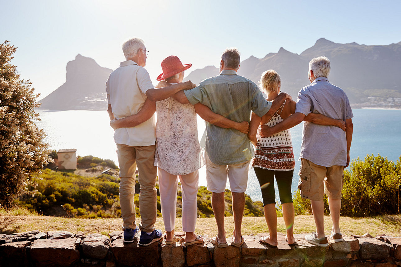 Fünf Menschen stehen zusammen und schauen aufs Meer