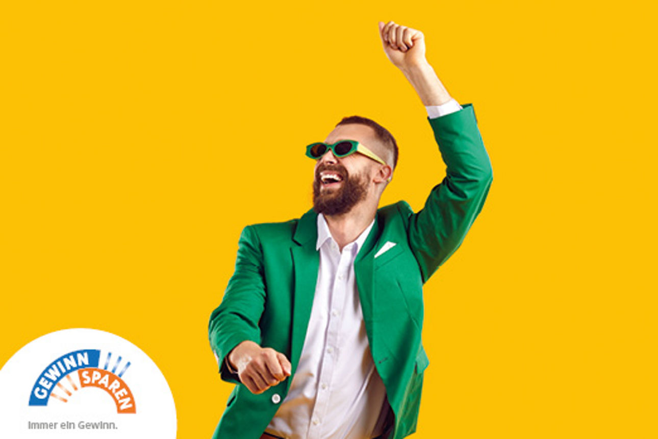 Ein Mann mit schwarzem Oberteil trägt weiße kabellose Teufel In-Ear-Kopfhörer vor blauer Wand.