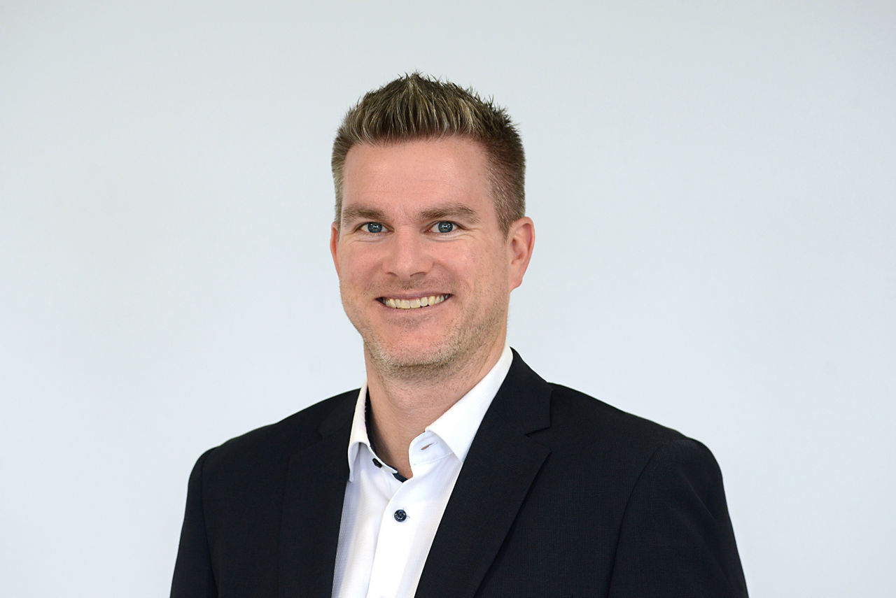 Firmenkundenberater Jörg Guardiera vor grauen Hintergrund