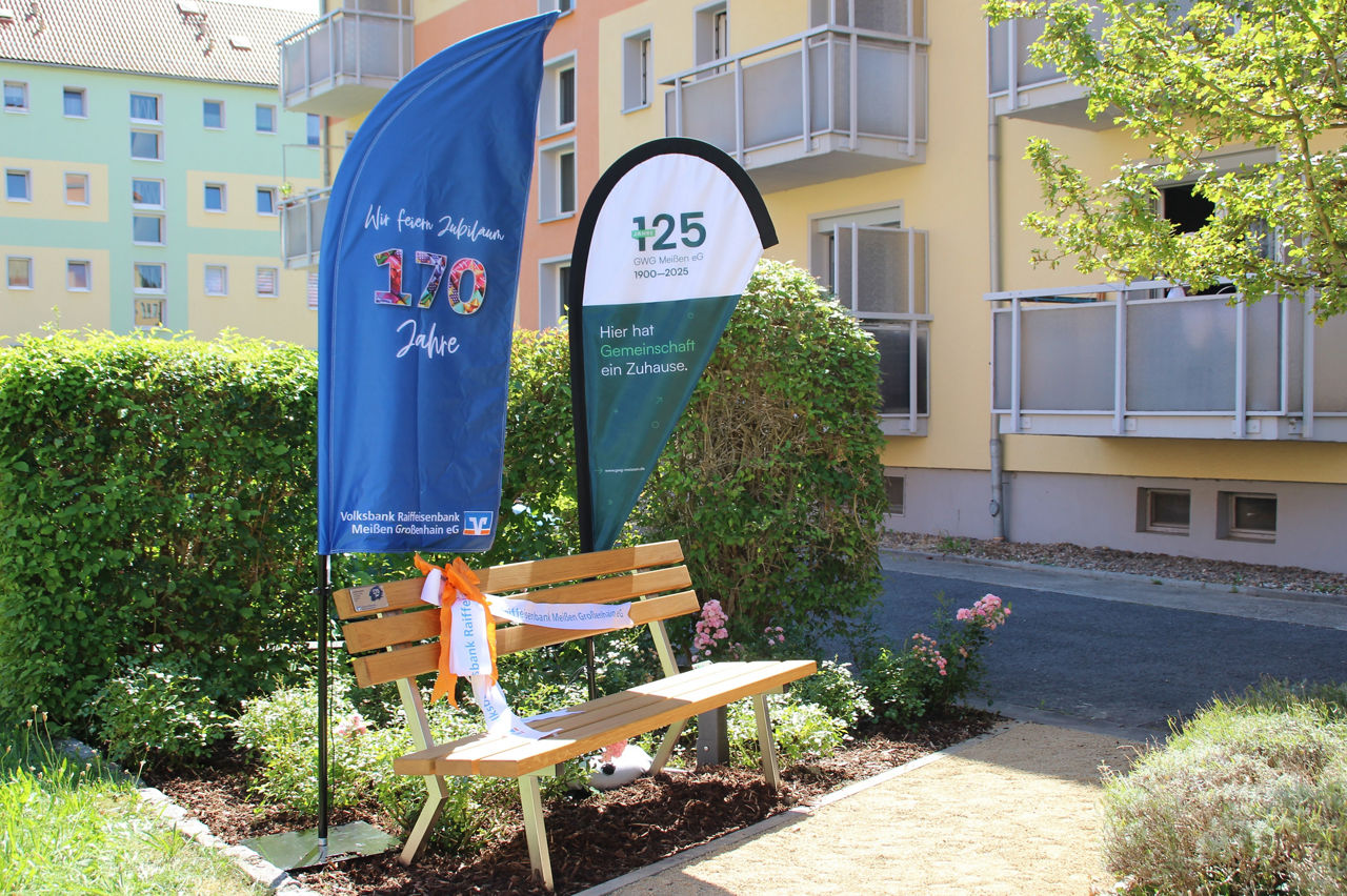 Eine Holzbank in einem Vorgarten beim Gebäude der GWG Meißen