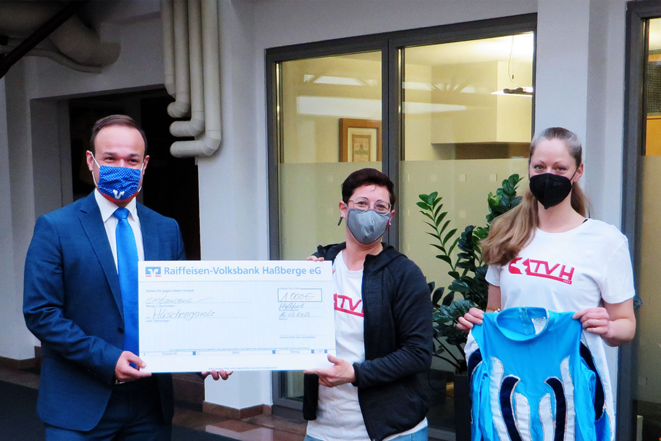 Christian Krines von der Raiffeisen-Volksbank Haßberge eG übergibt die Spende für die Häschengarde