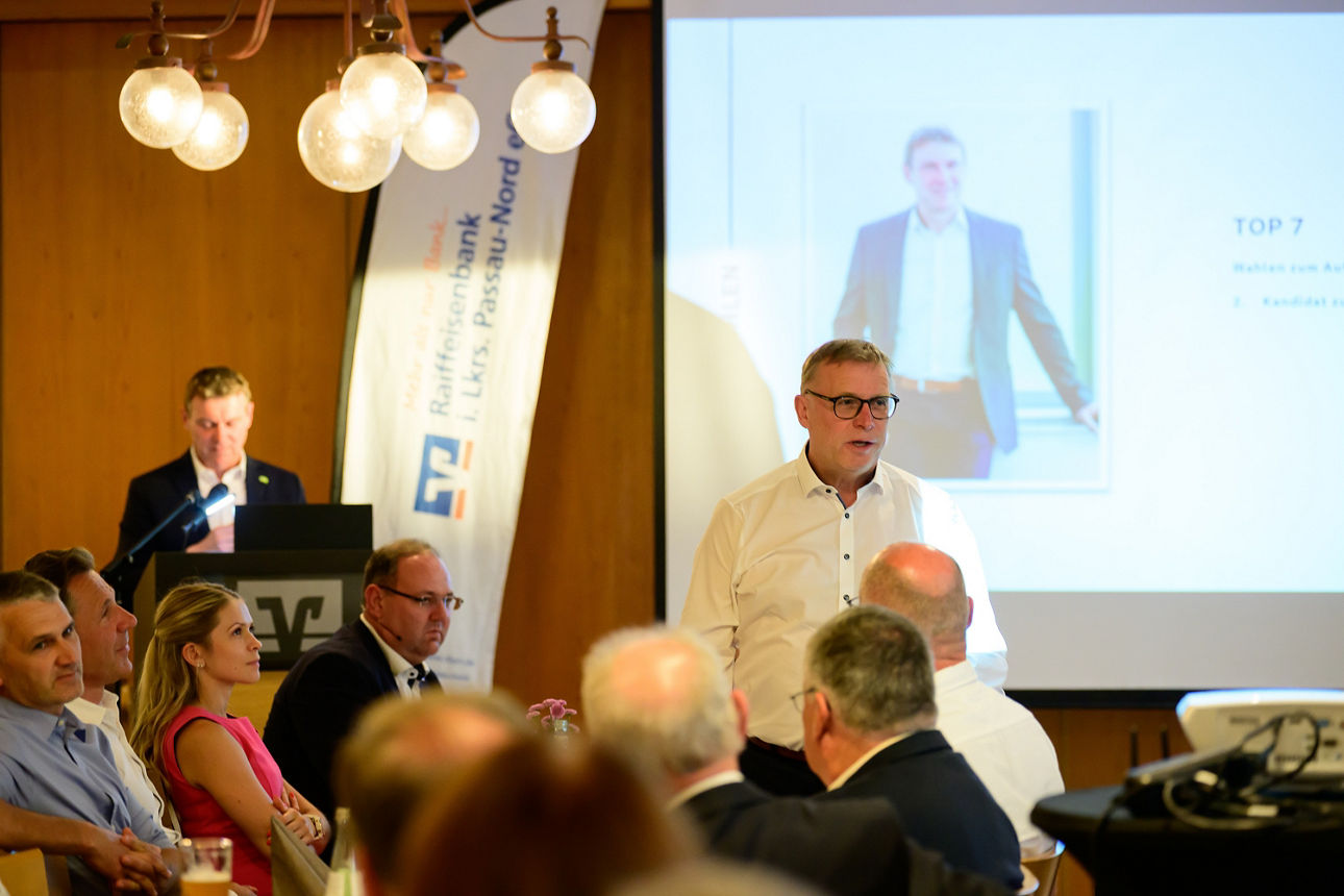 Ein Redner am Pult wärend ein anderer Herr zu den Vertretern spricht. 