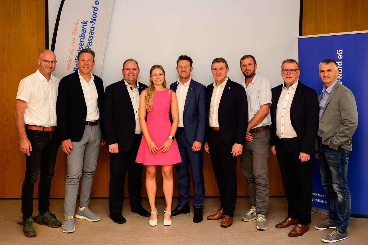 Ein Gruppenfoto vor einer Leinwand. 