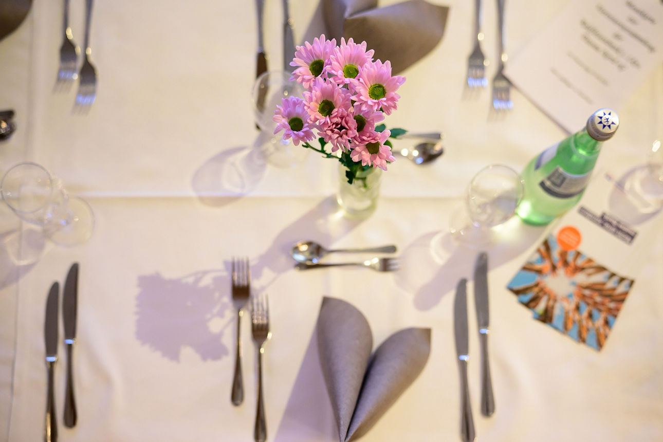 Ein gedeckter Tisch mit Blumen. 