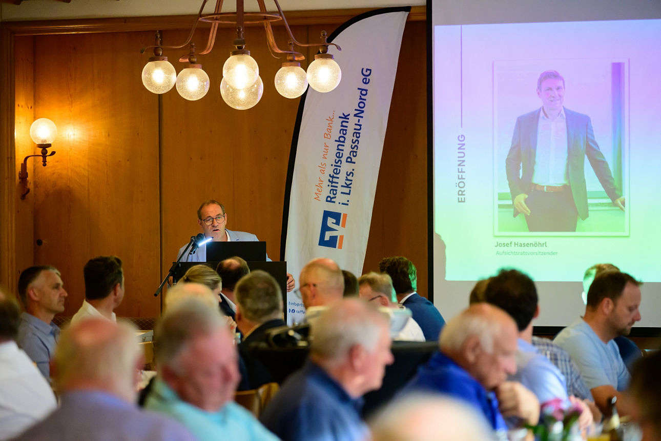 Die Gäste sitzen am Tisch und schauen auf die Leinwand. 