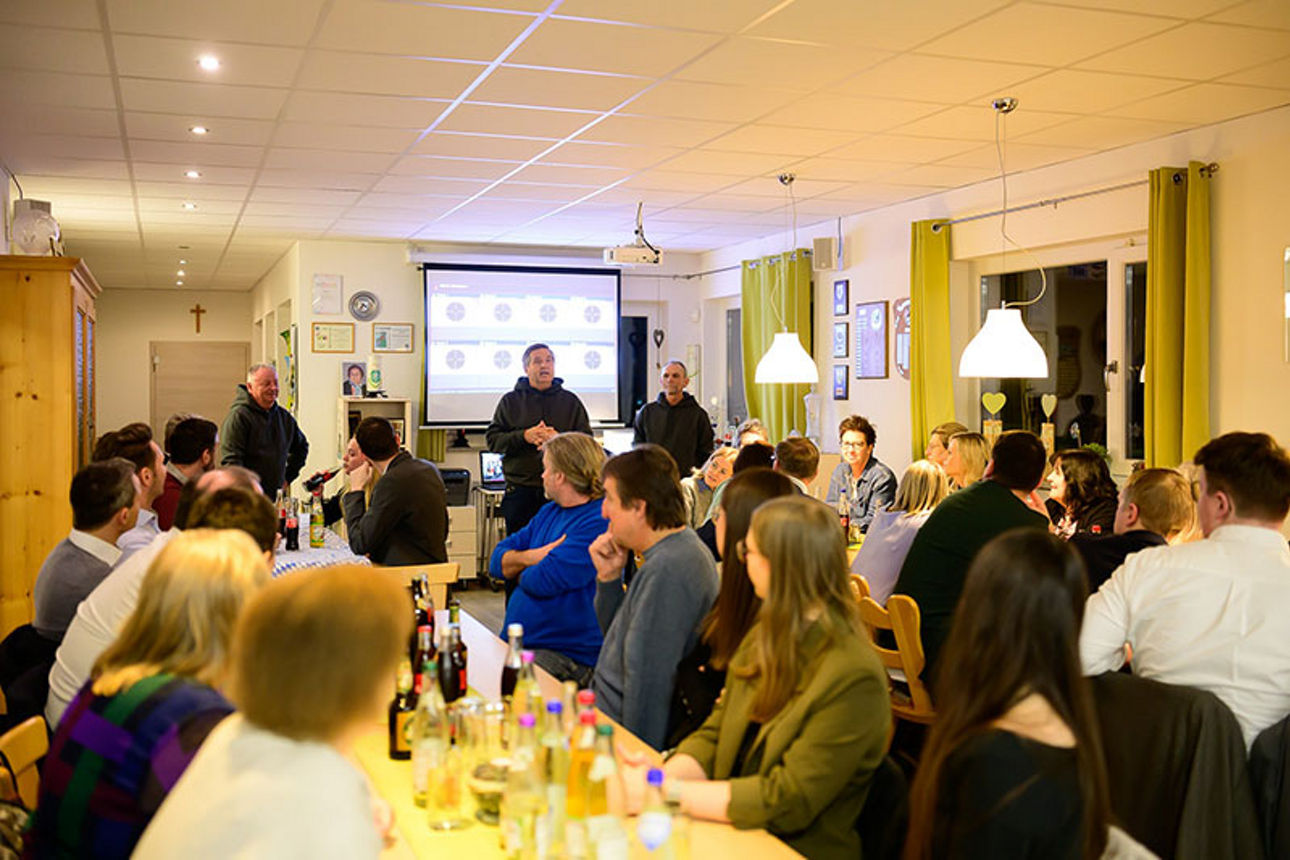 Menschen sitzen zusammen in einem Gastraum