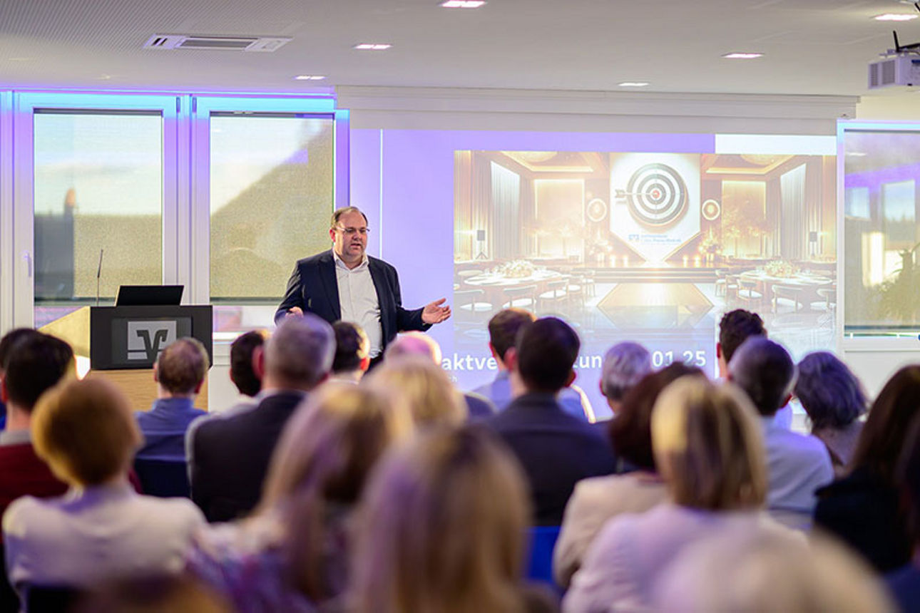 Mann präsentiert an einer Leinwand