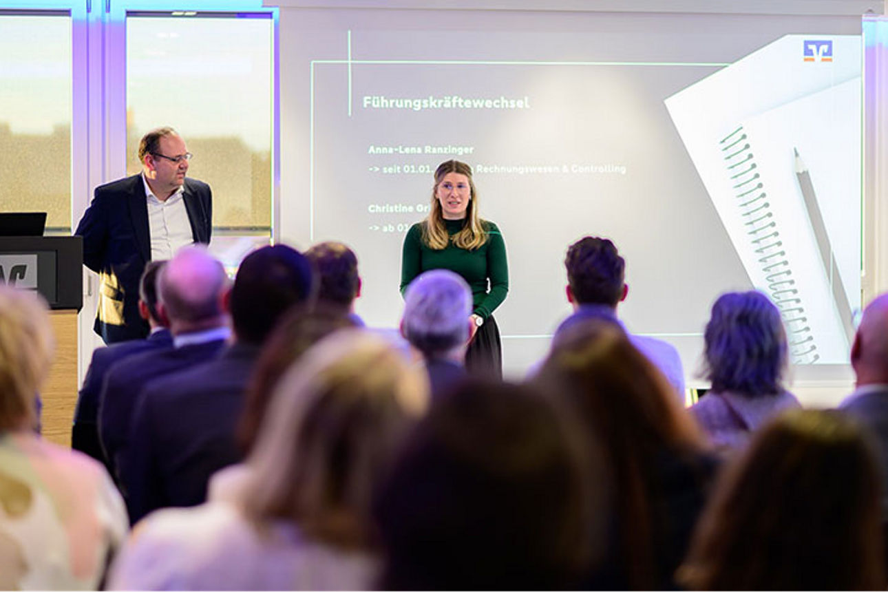 Frau steht vor einer Gruppe sitzender Menschen