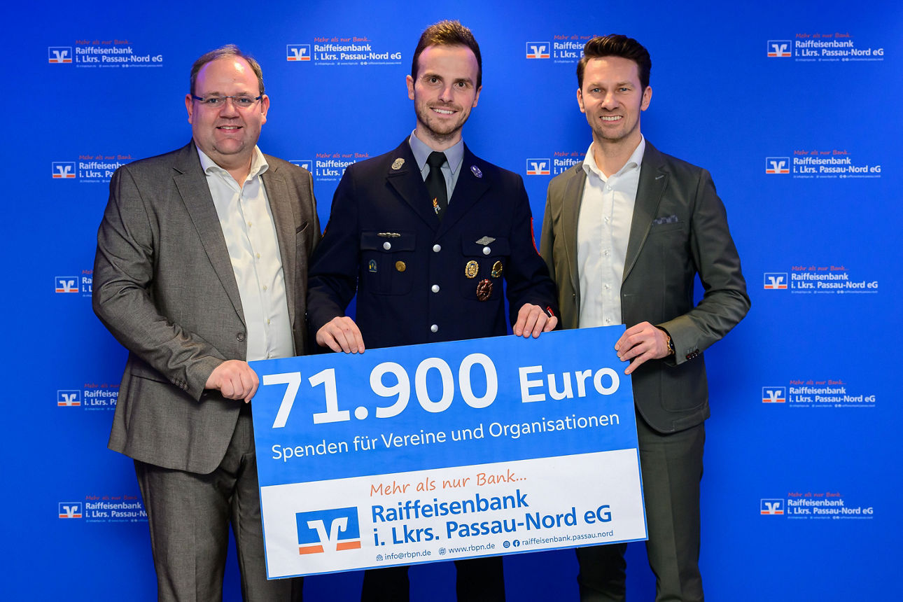 3 Männer halten einen Spendenscheck mit 71.900 Euro in der Hand