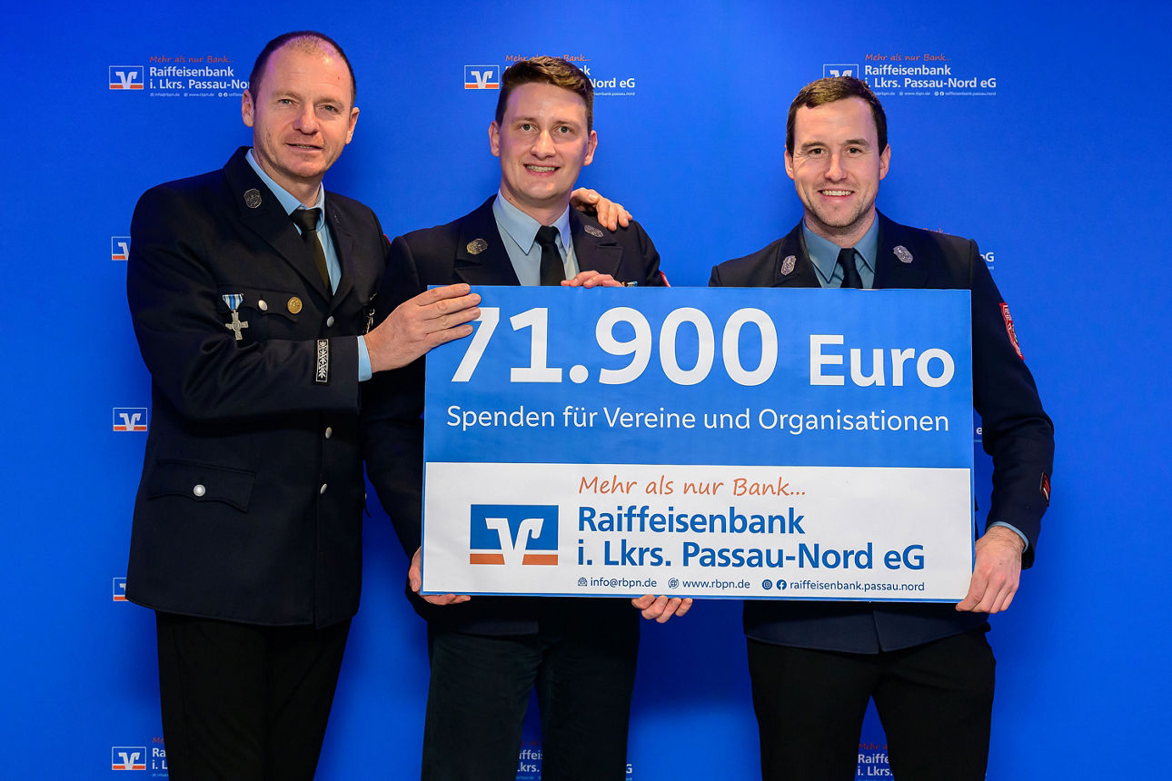 3 Männer halten einen Spendenscheck mit 71.900 Euro in der Hand