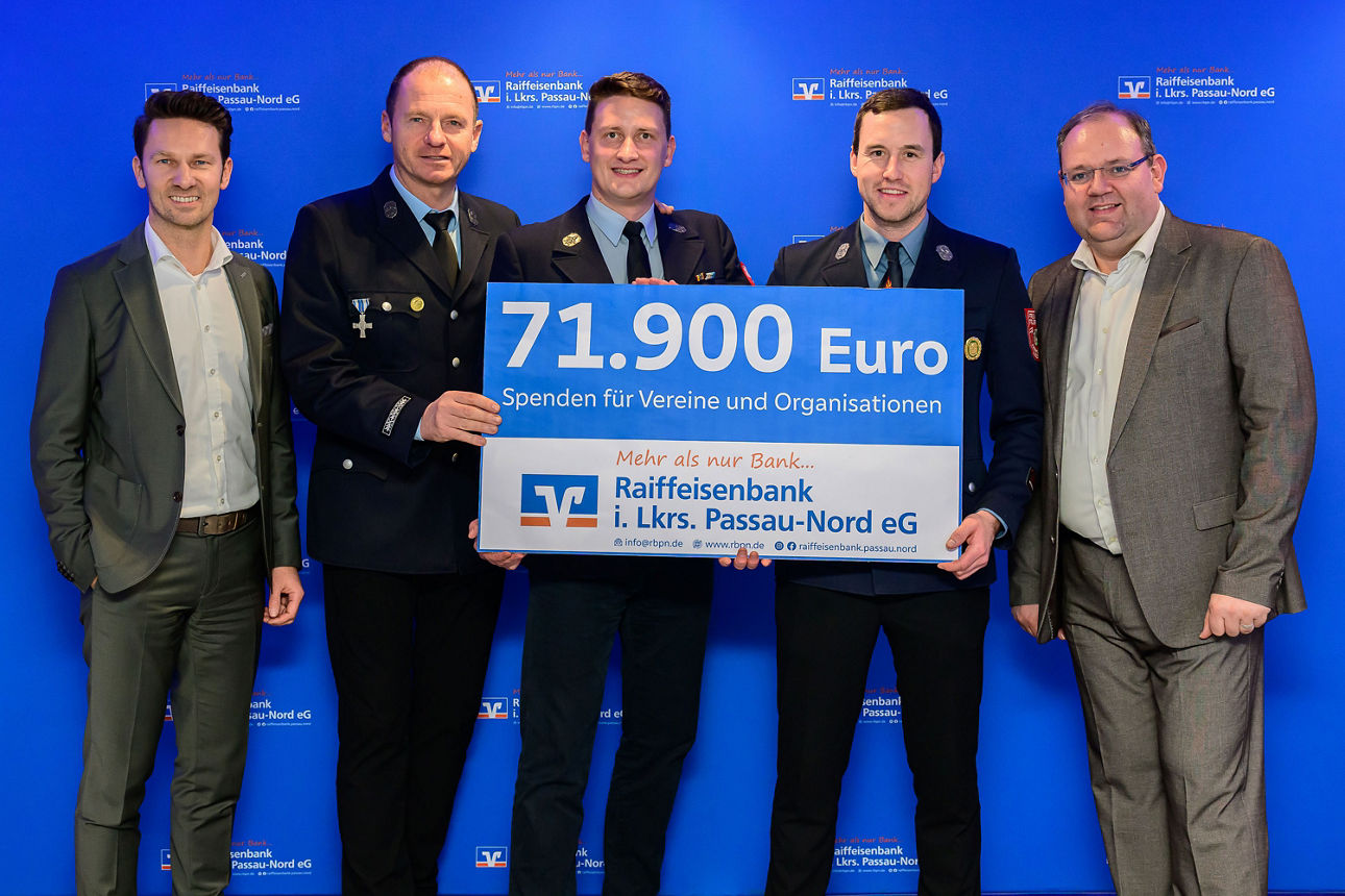 5 Männer halten einen Spendenscheck mit 71.900 Euro in der Hand