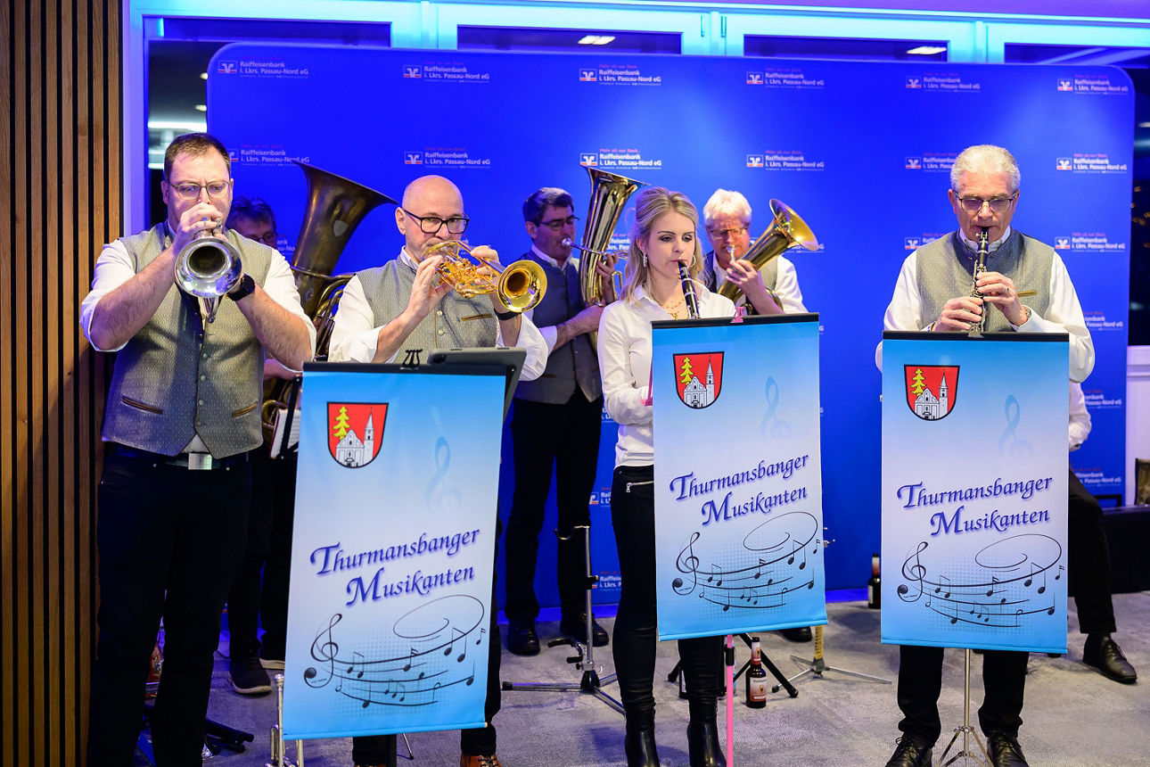 Eine Musikerin und sechs Musikanten beim spielen.