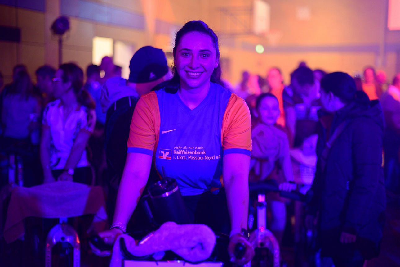 Frau auf Indoor-Fahrrad in Gruppe