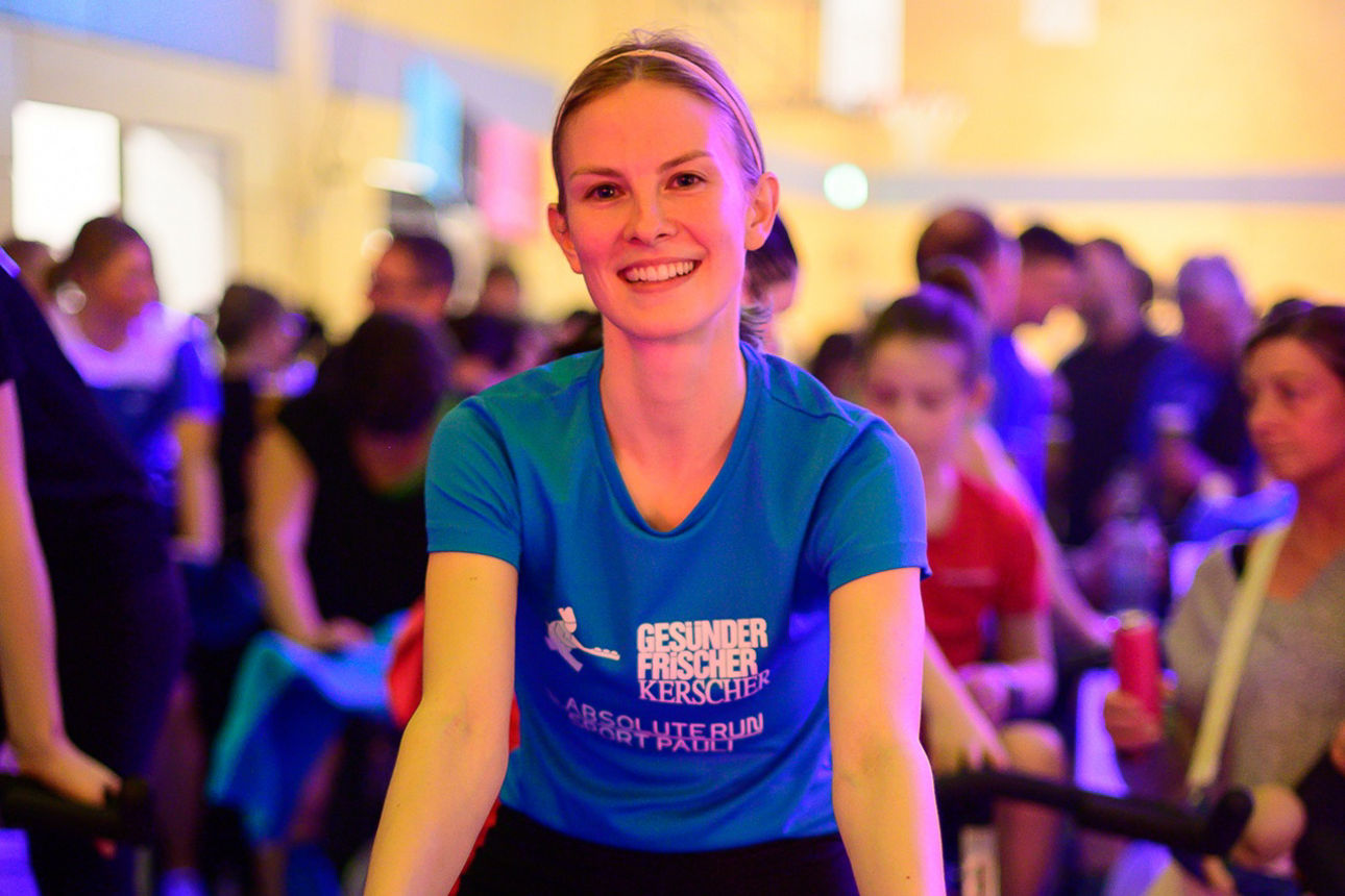 Frau auf Indoor-Fahrrad in Gruppe