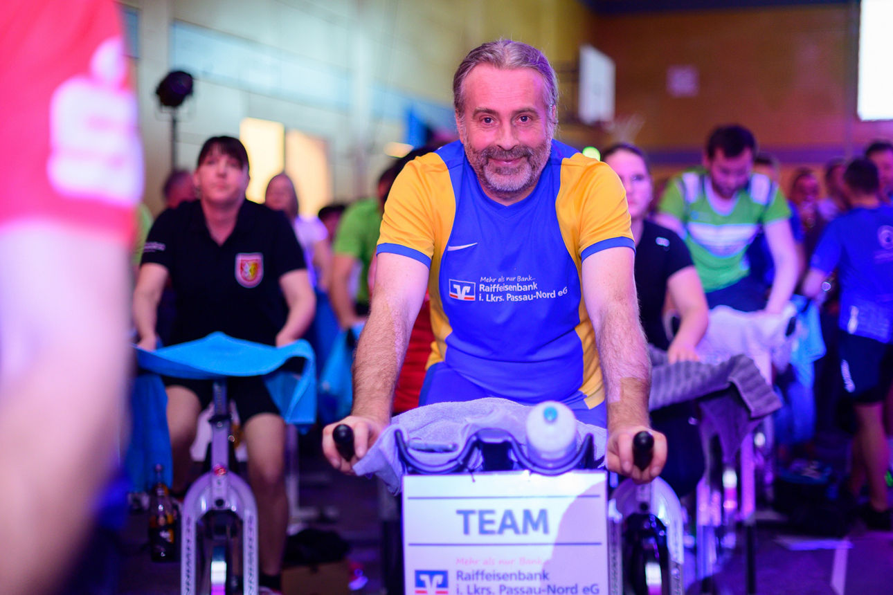Mann auf Indoor-Fahrrad in Gruppe
