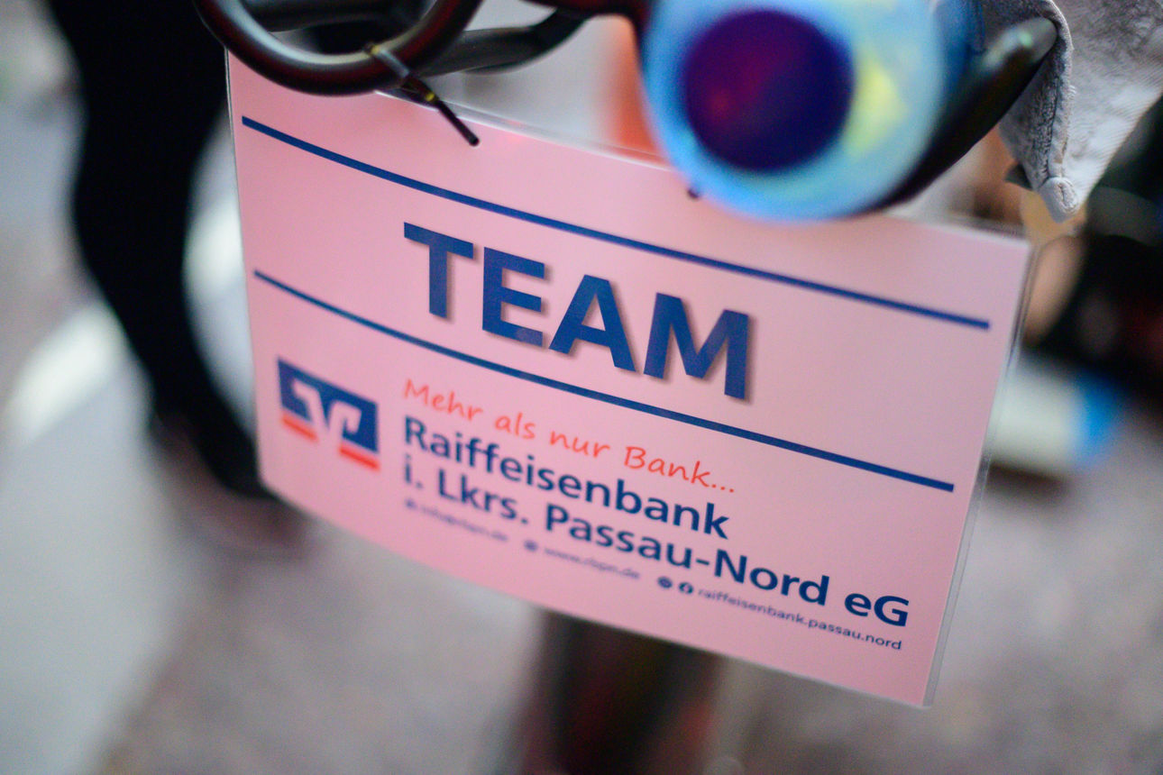 Schild auf dem Team und das Logo der Raiffeisenbank im Landkreis Passau-Nord eG zu sehen ist