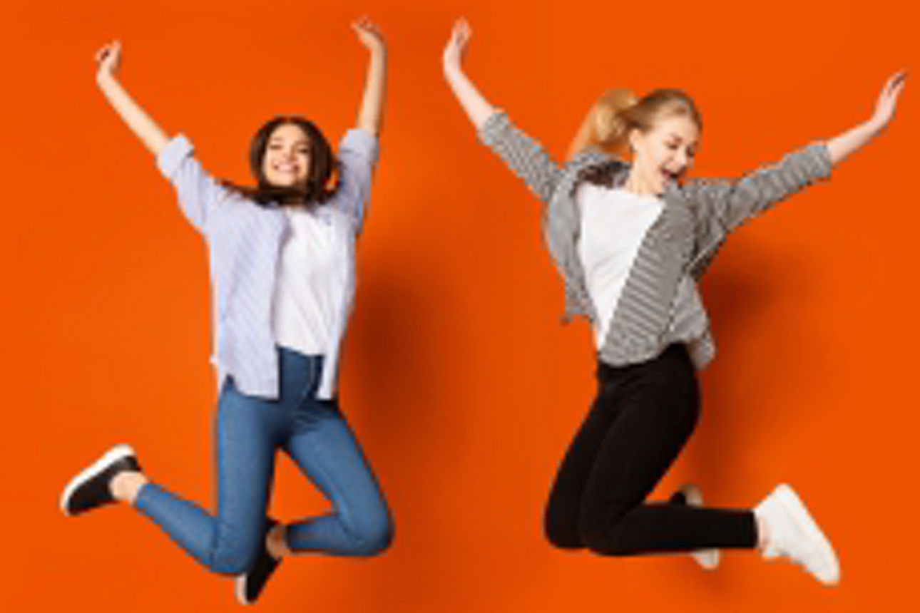 hüpfende Frauen vor orangem Hintergrund