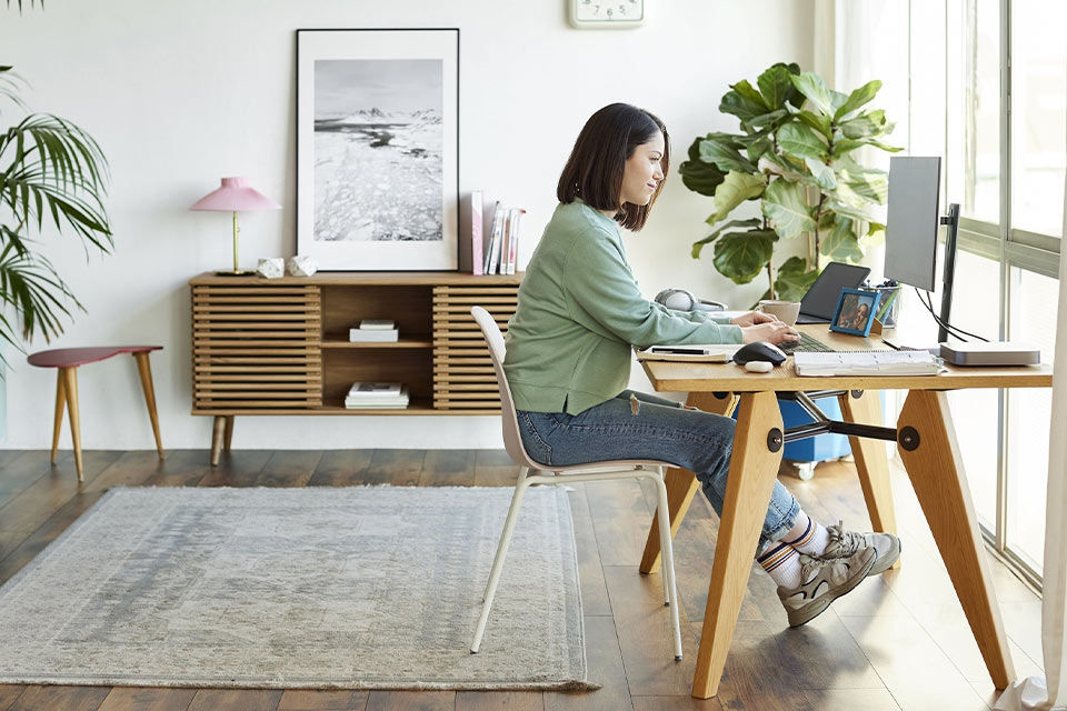 Eine Frau an ihrem Schreibtisch arbeitet an einem Computer