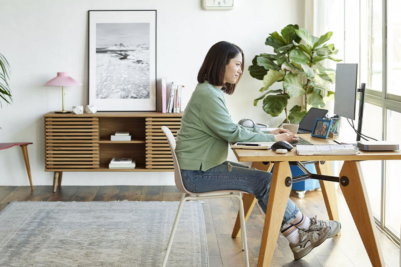 Eine Frau an ihrem Schreibtisch arbeitet an einem Computer