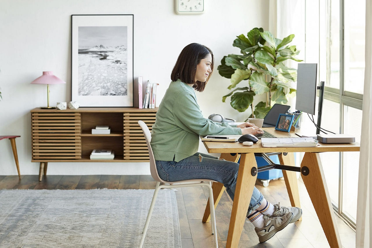 Eine Frau an ihrem Schreibtisch arbeitet an einem Computer