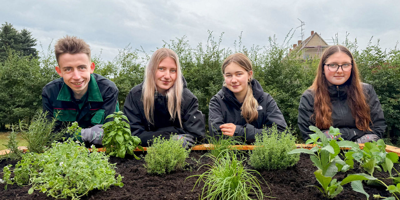 Unsere vier neuen Auszubis am Hochbeet des Etzdorfer Hofes an ihren ersten Ausbildungstagen