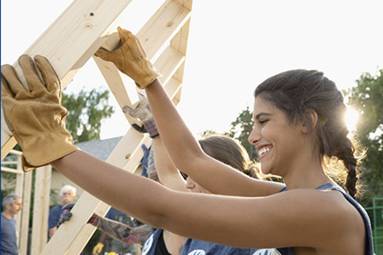 Gemeinsam wird eine Seitenwand aus Holz für ein Vereinsheim aufgestellt