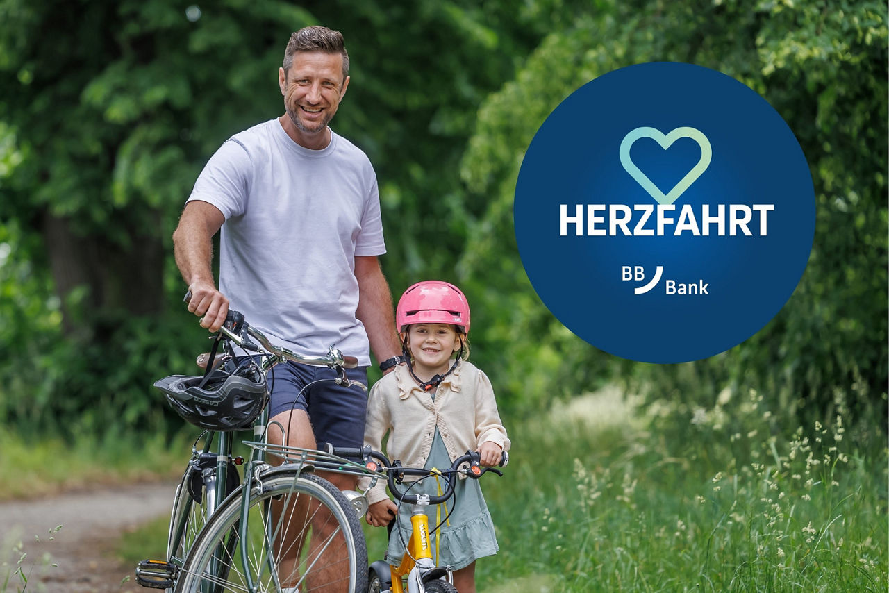 Vater und Tochter mit Fahrrädern stehen in einem Park und lächeln in die Kamera