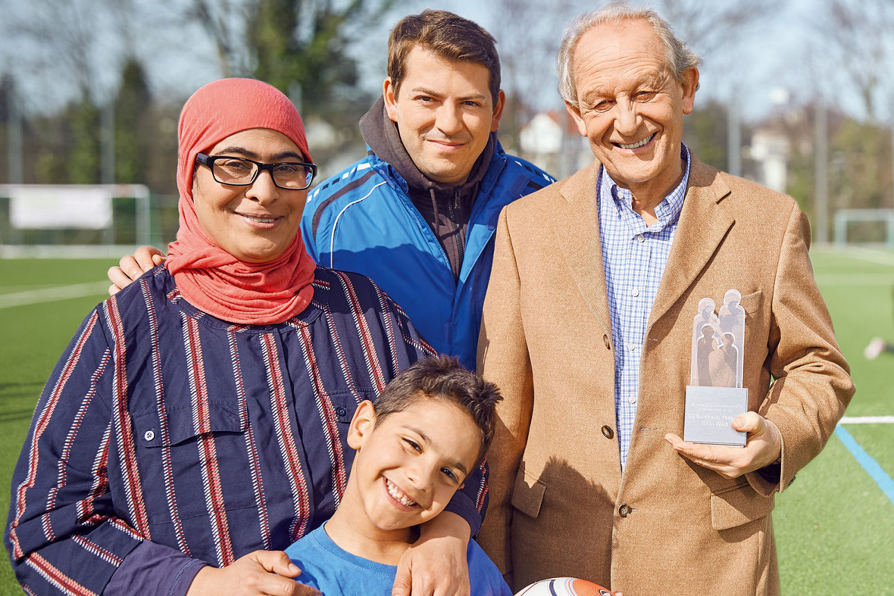 Menschen jeder Generation stehen auf einem Fussballfeld