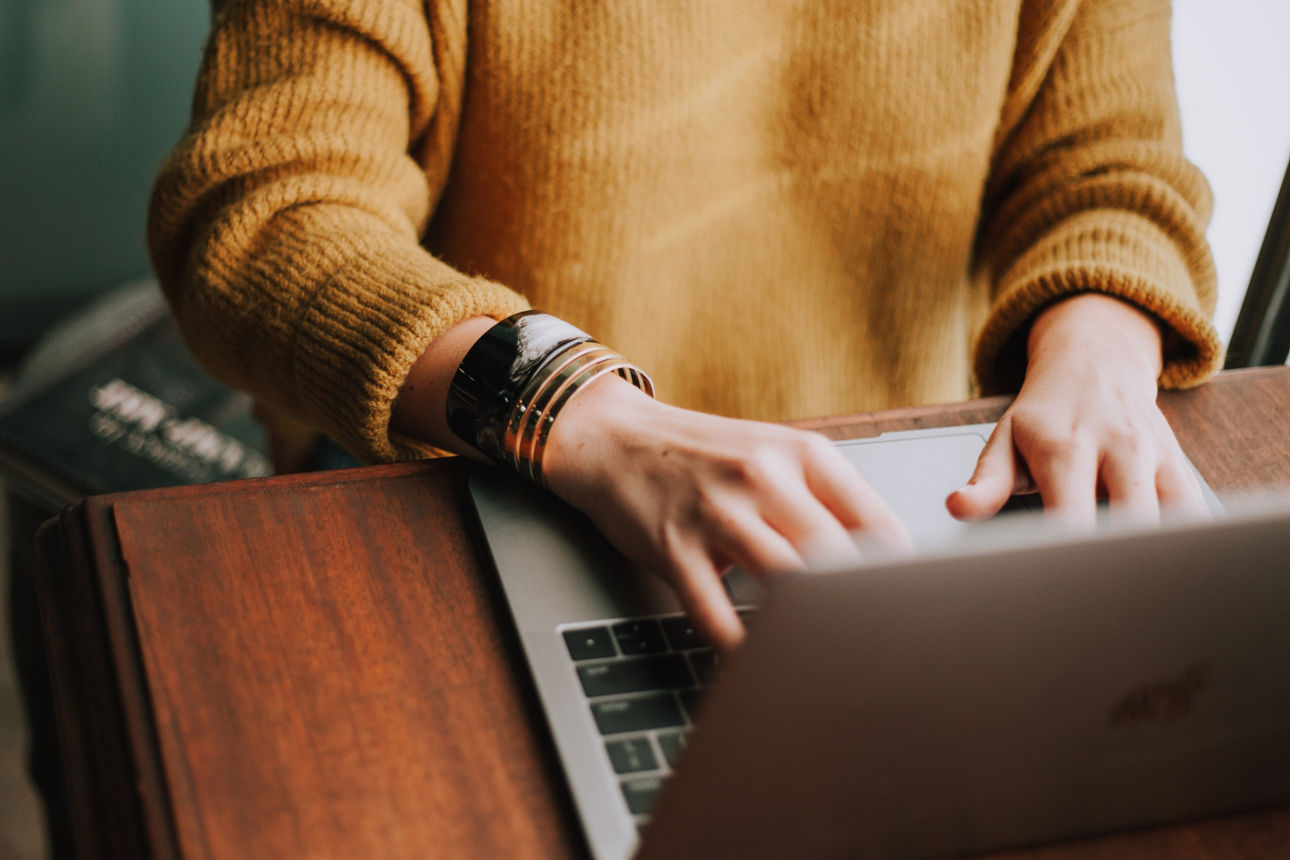 Ausschnitt von zwei Händen, welche am Laptop arbeiten