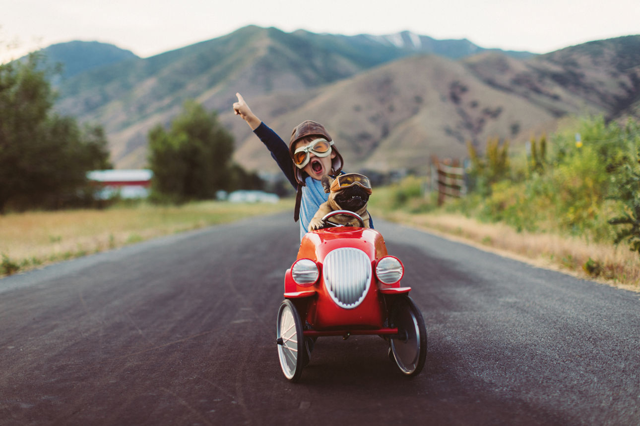 Kind mit Rennauto und Hund