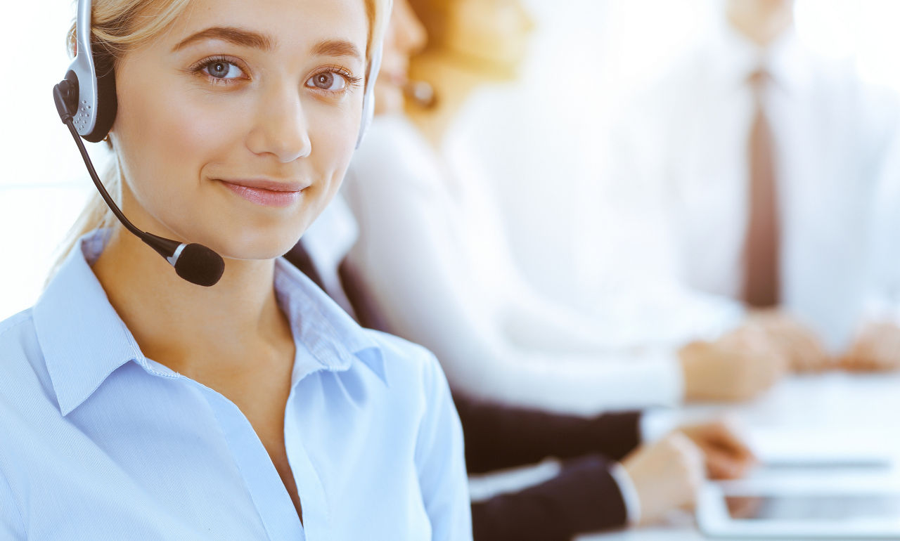 Blonde junge Frau mit Telefonkopfhörer