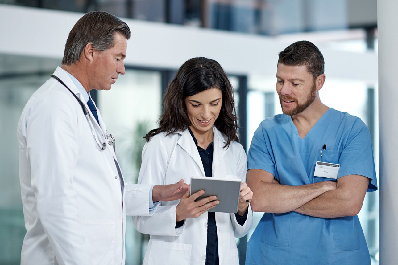 Drei Ärzte schauen auf ein Tablet