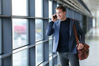 Ein Mann telefoniert unterwegs am Flughafen