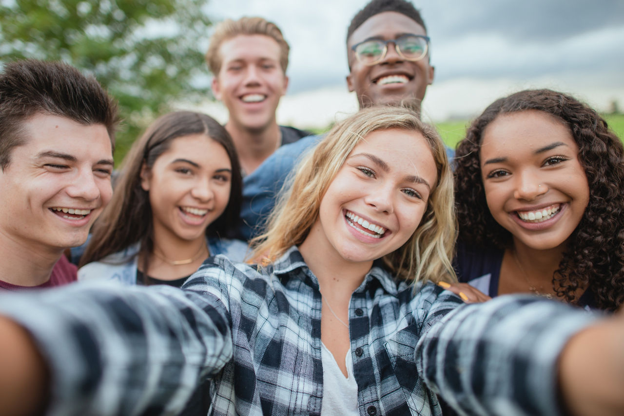 Eine Grupe junger Menschen macht ein Selfie.