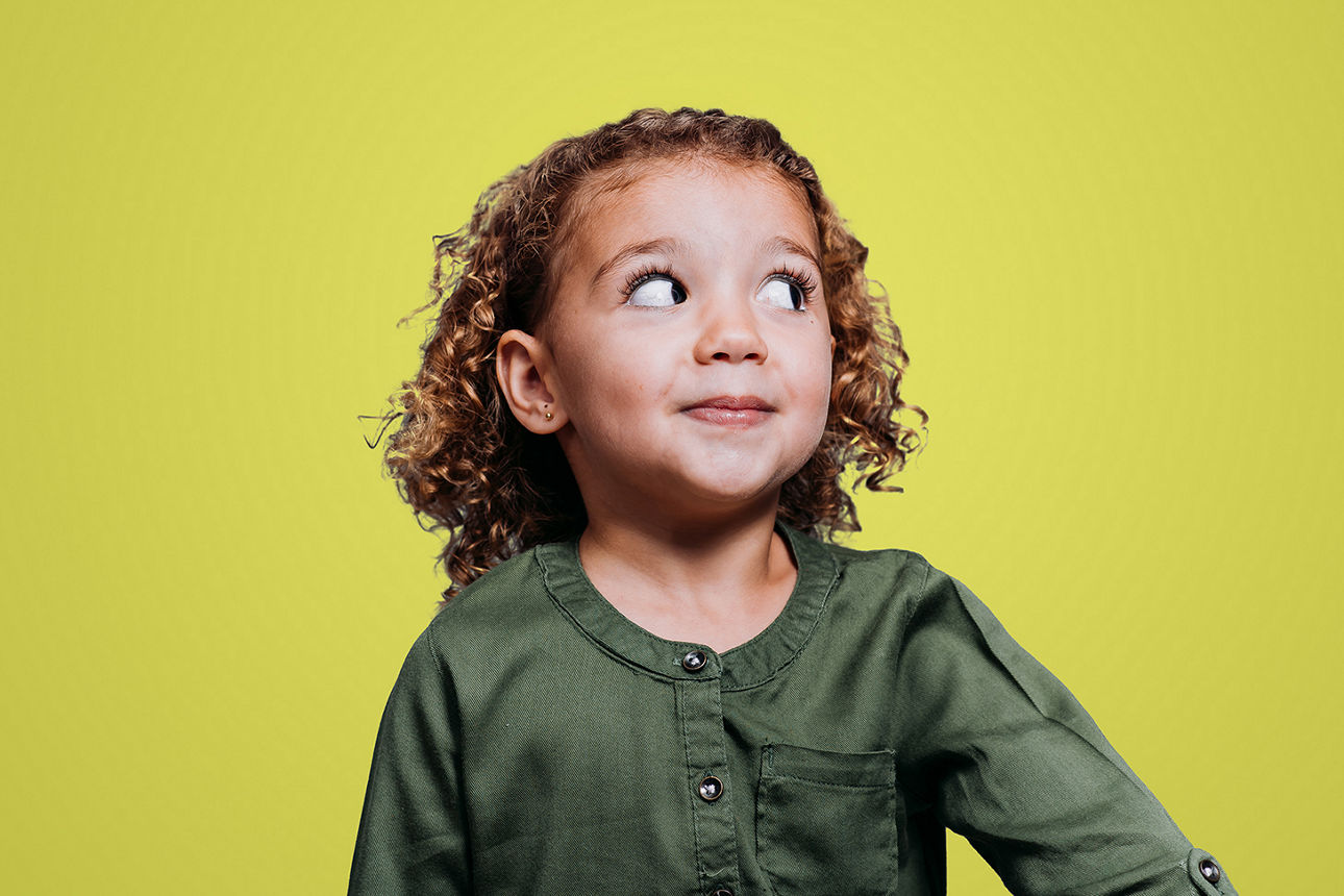 Ein kleines Mädchen guckt erwartungsvoll nach oben.