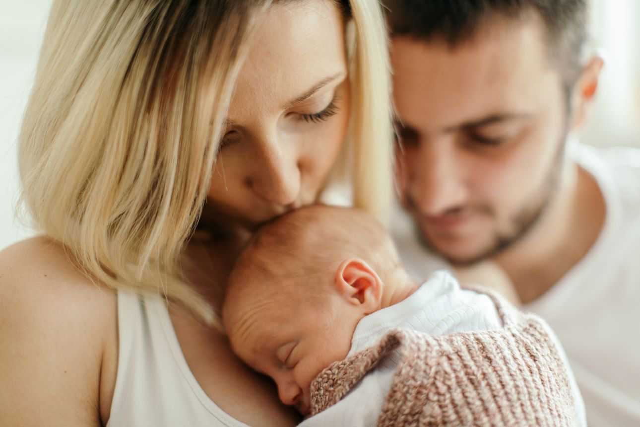 Junge Mutter und Vater mit ihrem Neugeborenen