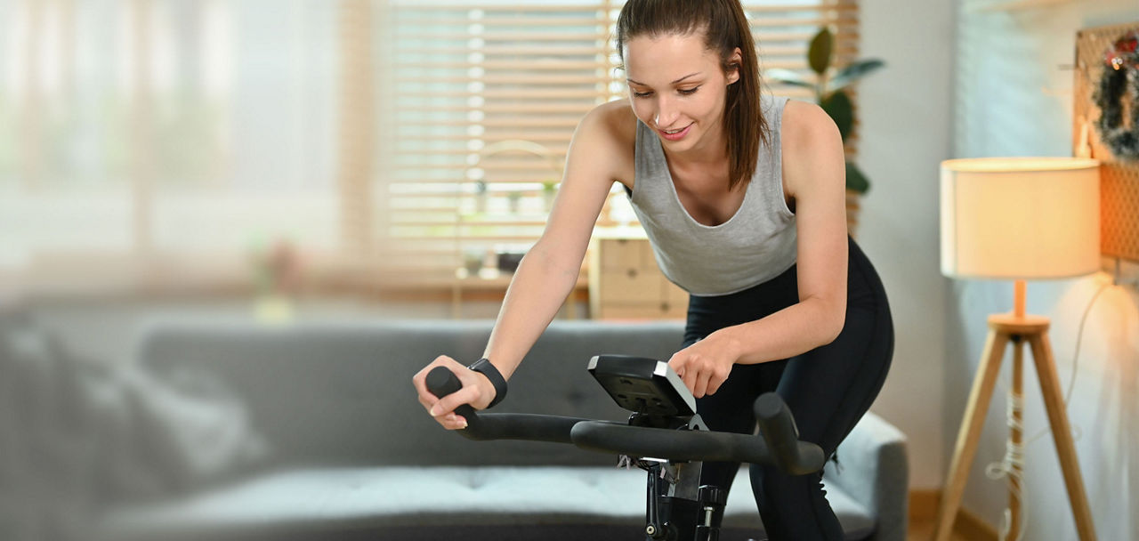 Eine Frau trainiert auf einem Indoor-Fahrrad