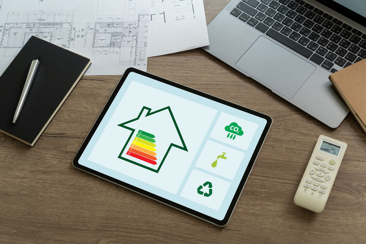 Ipad liegt auf einem Schreibtisch auf dem ein Haus mit einem Gebäude und Energieklassen zu sehen ist.
