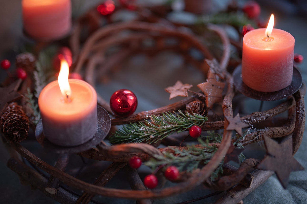 First Advent, wreath with a burning pink candle and Christmas decoration, festive home decoration, copy space, selected focus, shallow depth of field