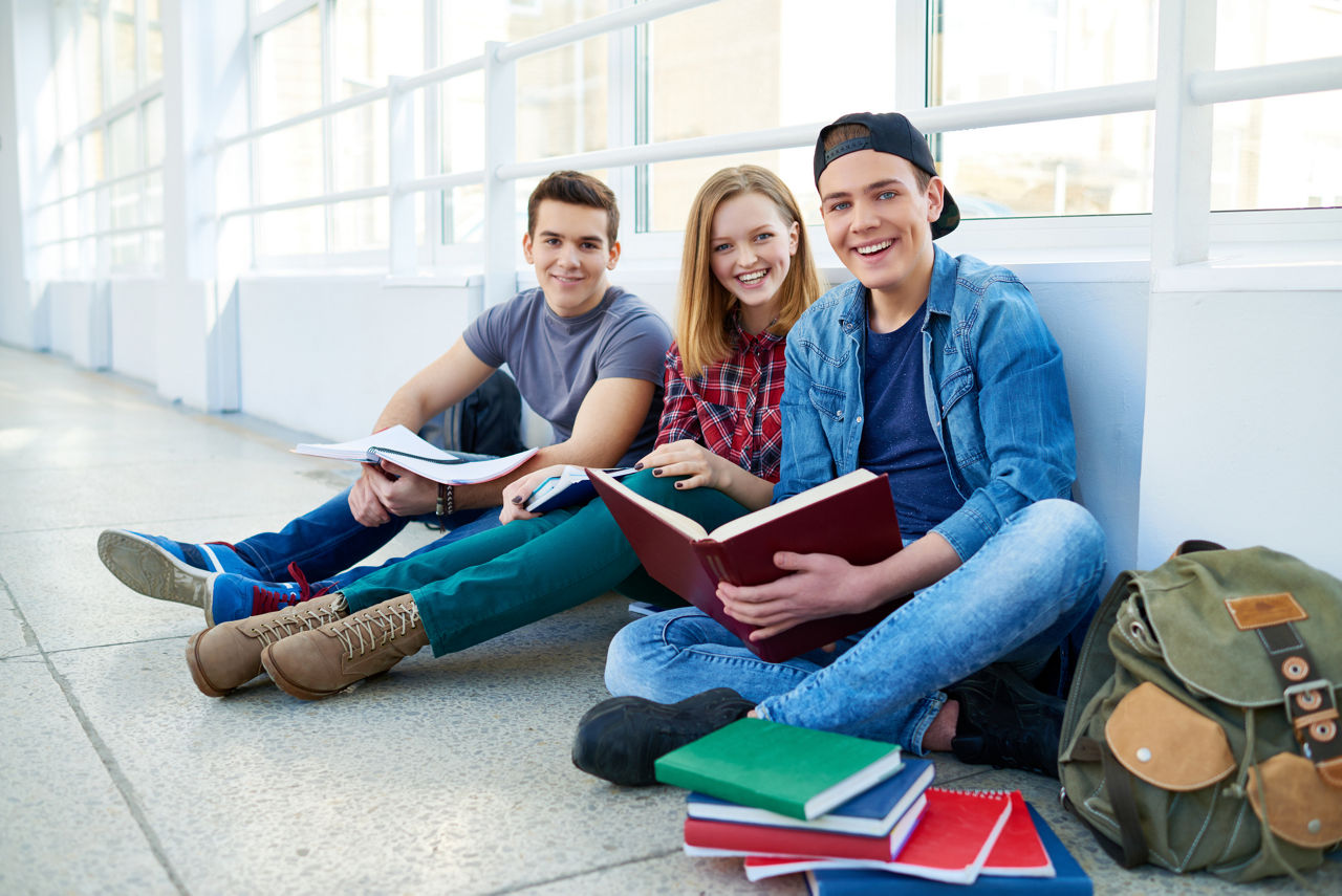 Jugendliche sitzen im Schulgang