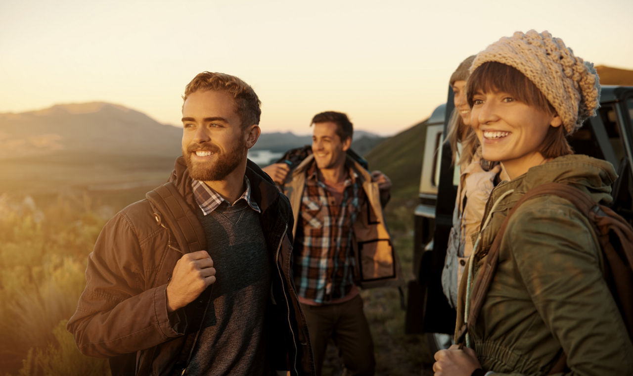 Eine Gruppe junger Leute beim Aufbruch zum Wandern am frühen Morgen
