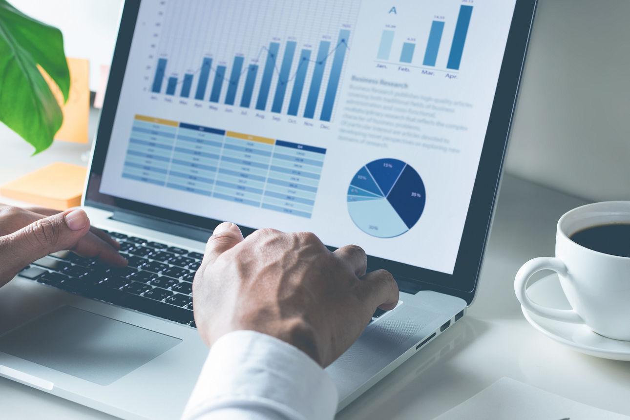 Young businessman typing computer laptop with graph chart for workYoung businessman typing computer laptop with graph chart for work