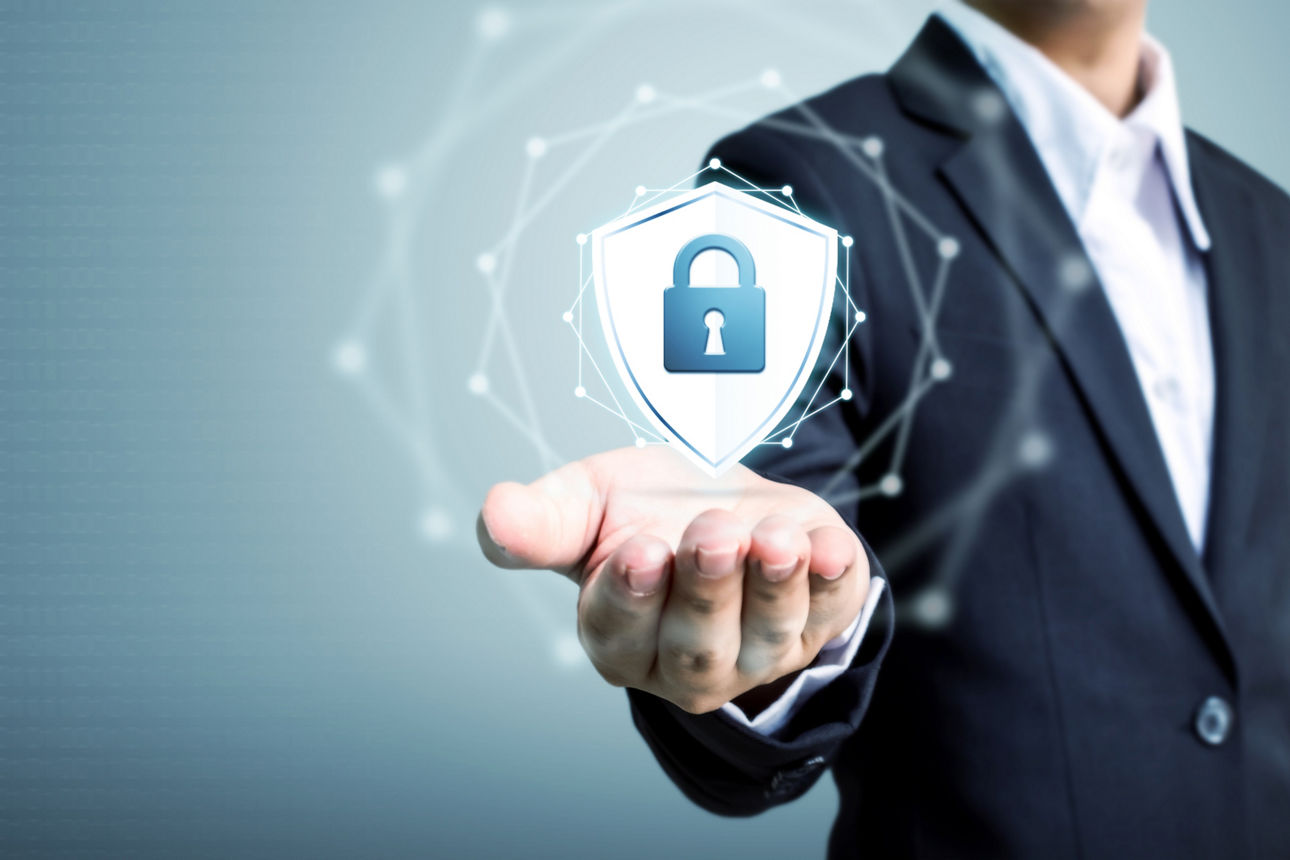 Ein Geschäftsmann hält Schild schützen Symbol in der Hand