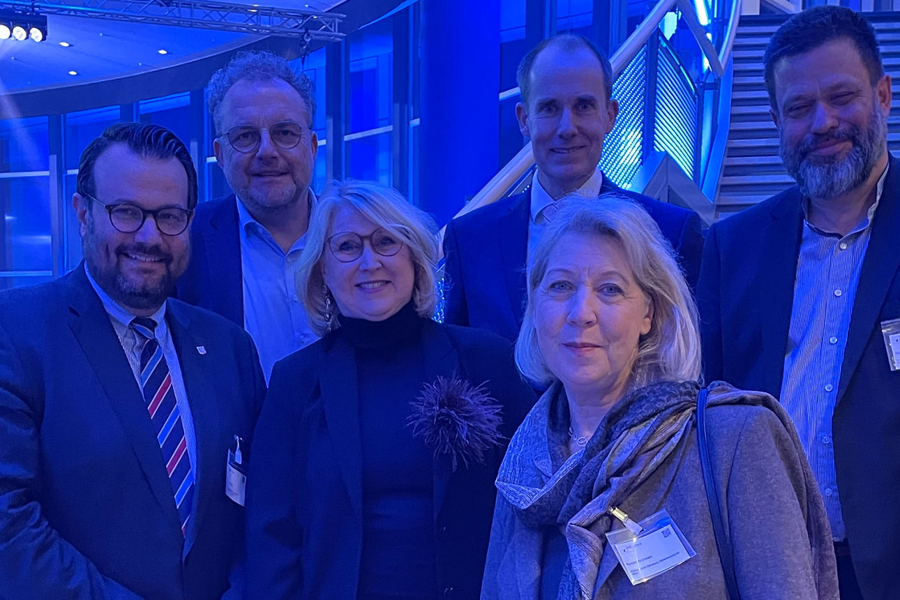 Mehrere Personen stehen lächelnd und versetzt auf einer Treppe.