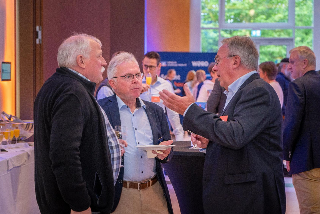 Männlich gelesene Vertreter im Gespräch im Foyer
