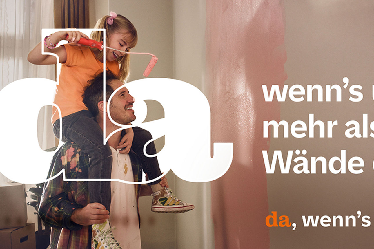 Vater hat seine Tochter auf den Schultern und streicht eine Wand