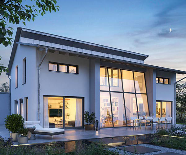 ein großes, modernes Haus, von innen warm beleuchtet.