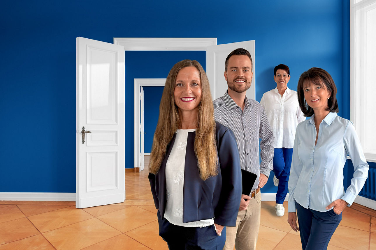 Drei Frauen und ein Mann stehen in einer leeren Wohnung