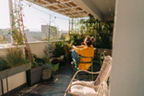 Frau genießt die Sonne auf dem Balkon.